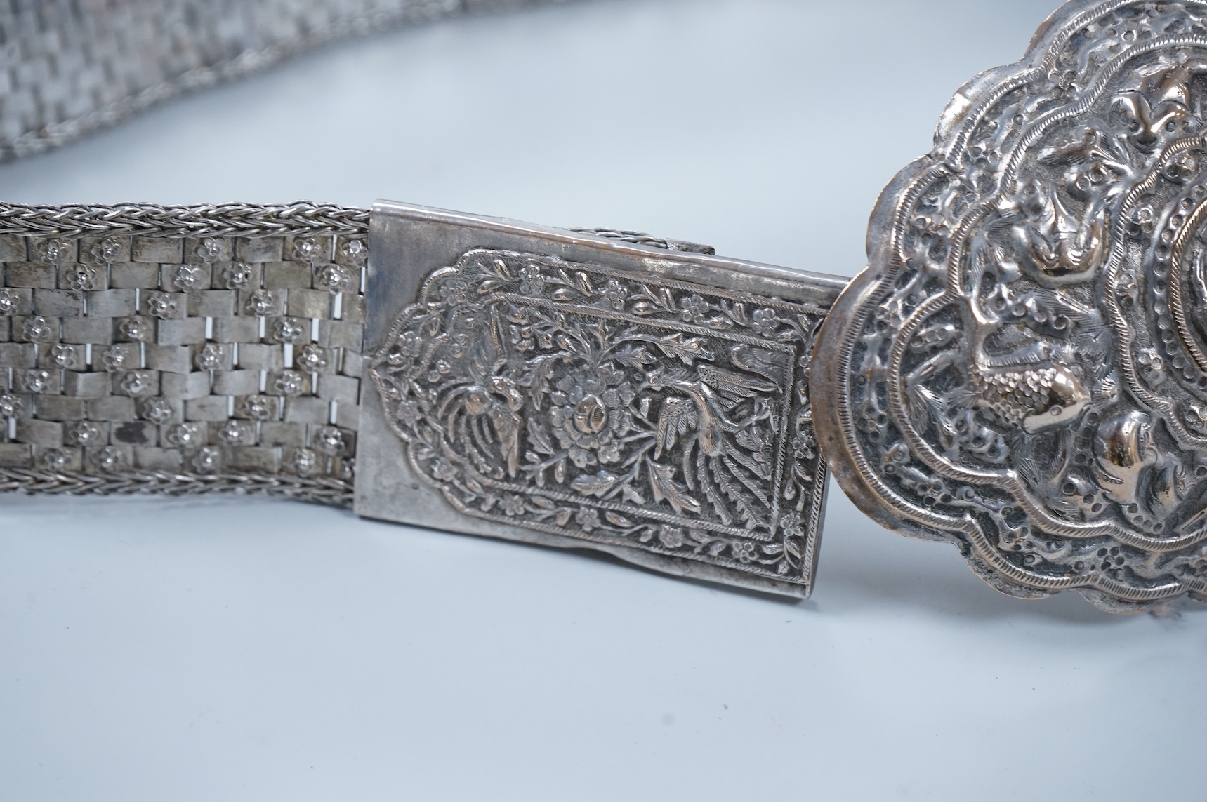 An early 20th century Chinese Straits repoussé white metal belt and buckle, stamped marks, 273g